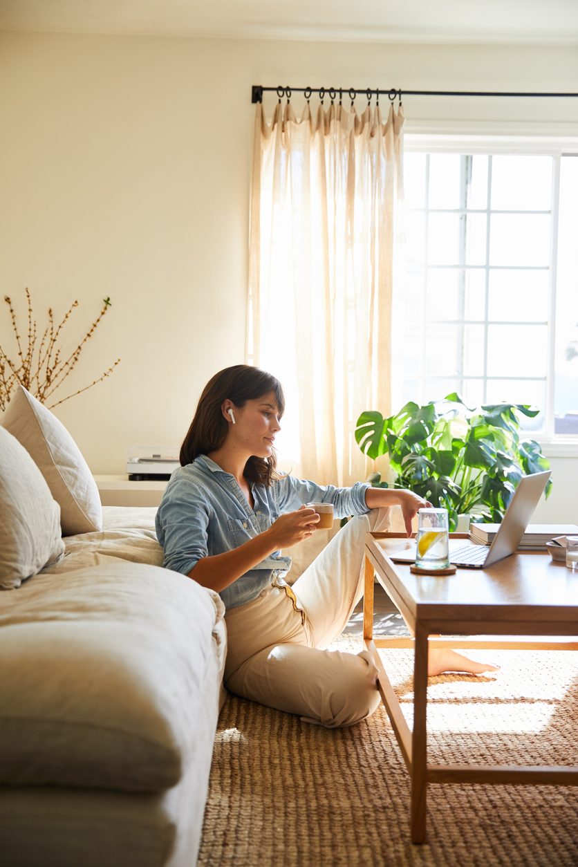 Woman watching something on a laptop in her living room